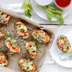 Buffalo Shrimp and Blue Cheese Potato Skins on a baking sheet with celery and blue cheese dressing.