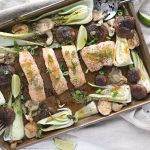 Orange Sesame Ginger Sheet Pan Salmon with baby bok choy and shitake mushrooms on a baking sheet