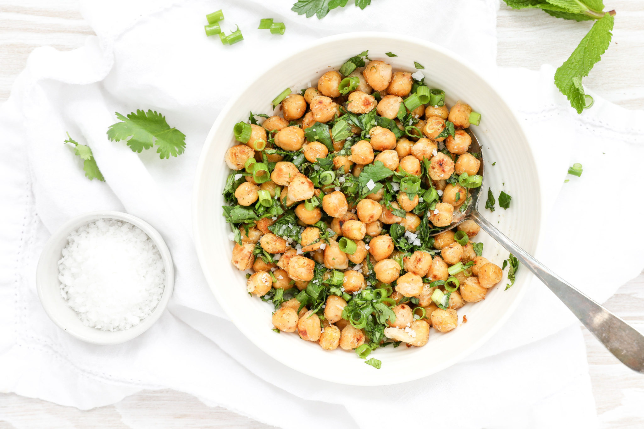 Pan Fried Chickpeas with Sea Salt and Fresh Herbs via JennySheaRawn.com An overhead shot of a bowl of chickpeas with fresh herbs in a white bowl