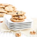 A stack of 4 cookies on a stack of white plates